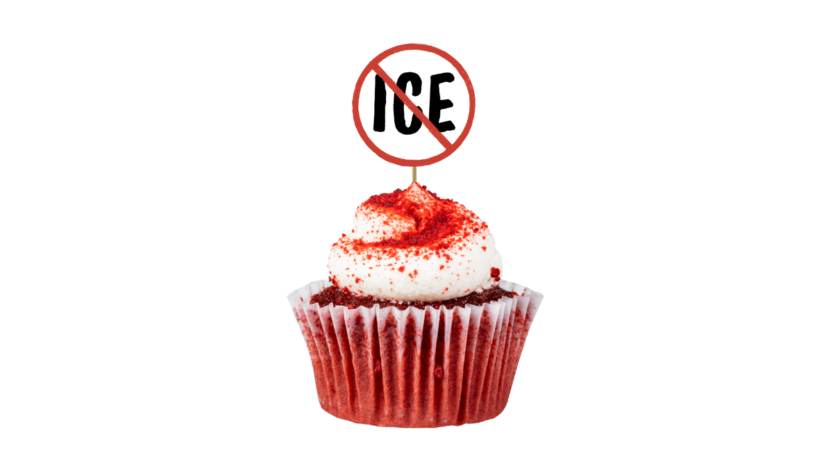 A close-up photo of a red velvet cupcake with white frosting and red sugar sprinkles, decorated with a toothpick flag with bold "ICE" text inside a red prohibition circle (no symbol)